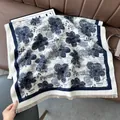 Macro shot of faux cashmere scarf with blue floral patterns and fine fringe detail - Pear Flower Blue