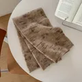 Dettaglio di una sciarpa in maglia di lana spessa con etichetta in pelle decorativa - 170x26cm / Marrone