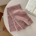 Dettaglio della sciarpa in maglia rosa e blu con etichetta in pelle su un tavolo - 170x26cm / Rosa