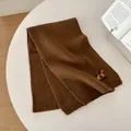 Dettaglio sciarpa marrone in maglia con ricamo di cane e morbida trama di filato - 160x27cm / caffè