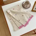 Detailed knit texture of a thick wool scarf featuring colorful dots and pink contrast edges - 155x27cm / Beige with Pink Border