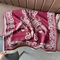 Dettaglio della sciarpa bordeaux con motivo paisley e frange morbide su pelle - Borgogna