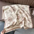 Dettaglio di scialle vintage floreale simil-cashmere con nappe su sedia di pelle - Cachi
