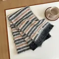 Close-up of soft wool blend striped scarf showing fluffy texture and woven brand label - 170x27cm / Black White Brown Multicolor