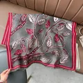 Detail eines Jacquard-Strickschals mit Blattmuster, rotem Rand und Fransen auf Leder - Blatt Dunkelgrau