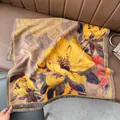 Nahaufnahme von dickem Kaschmir-Imitat-Schal mit Blumenmustern und Fransen auf Ledersofa - Große Blume Khaki