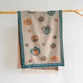 Dettaglio del motivo floreale di camelia vintage e nappe su una sciarpa in finto cashmere - Cachi Chiaro