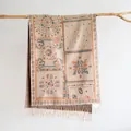 Close-up of Bohemian paisley jacquard shawl fabric texture with soft fringe tassels - Khaki