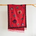 Dettaglio del foulard rosso effetto cashmere con motivi floreali vintage e nappe - Rosso