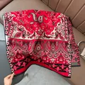 Close-up of red paisley pattern shawl with intricate floral motifs and fringe detail - Paisley - Red
