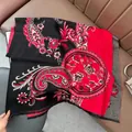 Close-up of winter pashmina shawl with red paisley patterns and black tassel details - Patchwork Paisley - Black Red
