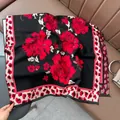 Detailed macro shot of vintage jacquard scarf with red floral pattern and leopard trim - Leopard Edge Floral - Black