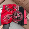 Close-up of red and black paisley cashmere-like scarf with fringe detailing on leather - Patchwork Paisley - Red Black