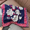 Detailed texture of jacquard shawl with white floral patterns and leopard print borders - Leopard Edge Floral - Blue