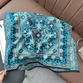Close-up of geometric pattern jacquard shawl with black fringe on a leather sofa - Lucky Pattern - Light Blue