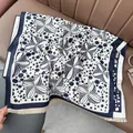 Dettaglio di una sciarpa pashmina blu e crema con frange su sedile in pelle - 180x65cm / Blu