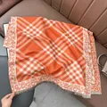 Detail of soft jacquard scarf with orange plaid pattern and leopard print tassel edges - 180x65cm / Orange
