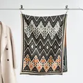 Dettaglio di una sciarpa in tessuto con motivi geometrici etnici e sottili frange corte - 180x65cm / Nero