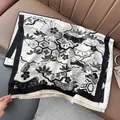 Detail van zwart-witte sjaal met oosterse motieven en afgewerkt met franjes - Zwart
