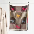 Detalle de bufanda con estampado de caballos y flecos, junto a un abrigo de lana beige - Color 3 - Estampado de Caballo Étnico Café Multicolor