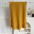 Détail d'une écharpe jaune moutarde aspect cachemire avec franges et étiquette rose - Curcuma