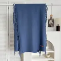 Vue détaillée de l'écharpe bleu marine aspect cachemire avec franges et étiquette - Bleu Denim