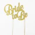 Dettaglio del cake topper Bride to Be in oro glitterato con bastoncini in legno di nozze - Oro