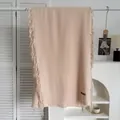 Détail de l'écharpe rose pâle en imitation cachemire avec franges et étiquette de marque - Poche zippée