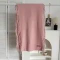 Écharpe rose effet cachemire avec franges et étiquette de marque sur un cintre - Rose
