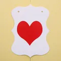 Dettaglio di etichette regalo a forma di cuore con stampa rossa e bordi decorativi - Pezzo di Cartoncino a Cuore Bianco