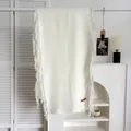 Gros plan d'une écharpe blanche au toucher cachemire avec des franges et étiquette - Blanc Lait