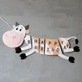 Cartoon cow themed Happy Birthday banner with black letters and white hanging string - Cow