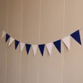 Detail of dark blue and light pink triangle pennant banner hanging on a textured wall - Navy Blue and White Triangle / Dark Blue / White