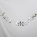 Dettaglio dello striscione Just Married argento a specchio con riflessi metallici - Stile Just Married Tondo Argento