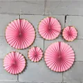Detail of pink and gold foil paper fan set hung on a wall for festive party decoration - Pink Gold Edge
