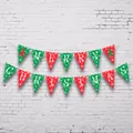 Close-up of red and green Merry Christmas bunting banner with snowflake and tree prints - Triangle Flag Style