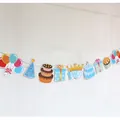 Colorful 1st birthday banner with party icons and crown hanging on a white wall - Blue First Birthday Theme (Crown Party)