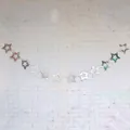 Silver mirror finish hollow star banner hanging on white textured wall for party decor - Silver Hollow Style