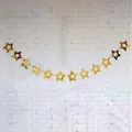 Detail of hanging gold hollow star garland with metallic finish for party decoration - Gold Laser Cut Style