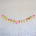 Close-up of ice cream and cupcake paper banner decorations on a white brick wall - Triangular Ice Cream Banner