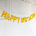 Striscione dorato glitter HAPPY BIRTHDAY su parete bianca per decorazione festa - Glitter Oro (HAPPY BIRTHDAY)