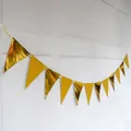 Golden metallic triangle bunting banner hanging against a minimalist white wall decor - Glitter and Mirror Gold Triangle / Glitter Gold / Mirror Gold
