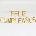 Gold glitzerndes spanisches Feliz Cumpleaños Geburtstagsbanner vor weißer Wand - Massiver Stil / Gold