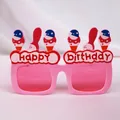 Ροζ γυαλιά πάρτι Happy Birthday με χρωματιστά στολίδια σε απαλό υφασμάτινο φόντο - Q Ροζ Παγωτό Γενεθλίων