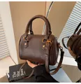 Detail of vintage brown leather Boston bag with textured finish and golden buckles - One Size / Coffee