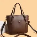 Classic dark brown lychee leather tote bag with wide strap and golden hardware - Brown