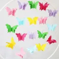 Detailaufnahme bunter 3D-Papier-Schmetterlinge, die an einem weißen Rundrahmen hängen - Regenbogen Groß