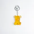 Transparent yellow resin bear keychain with golden gears and a silver metal clasp - Citrine