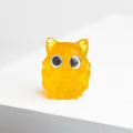 Détail d'une figurine de chouette en résine orange avec texture cristal et yeux bleus - Style Citrine