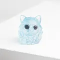 Vue macro d'une figurine de chat en résine bleu clair translucide avec collier à cloche - Style Aigue-marine